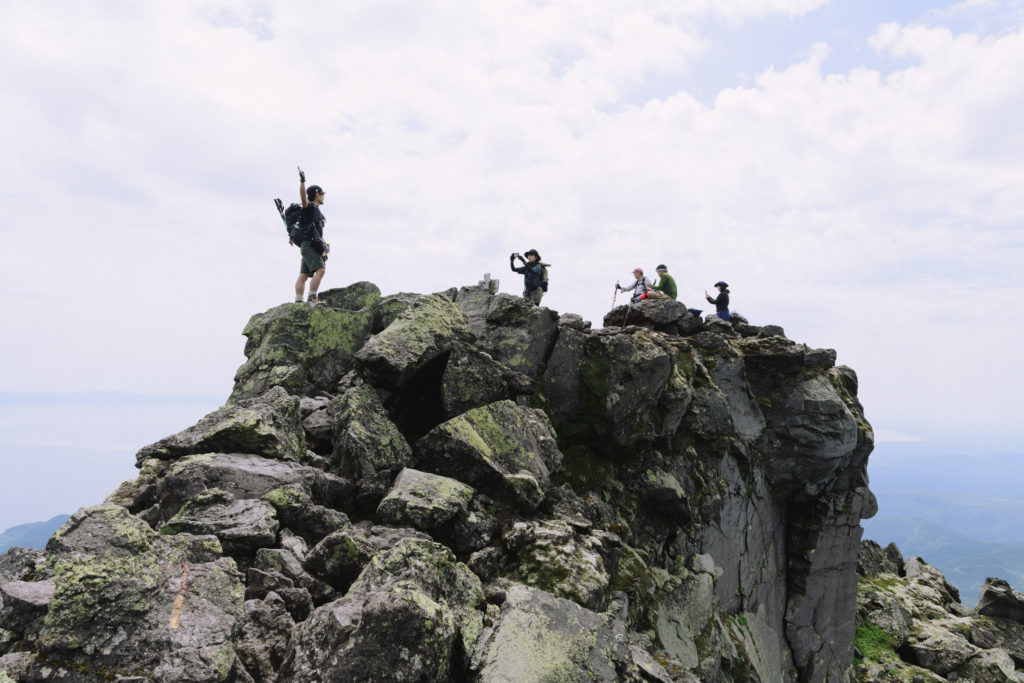 羅臼岳山頂で写真を撮る人