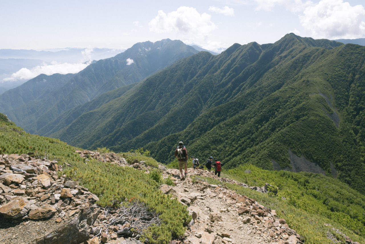 駒津峰から南アルプス南部を眺める登山者