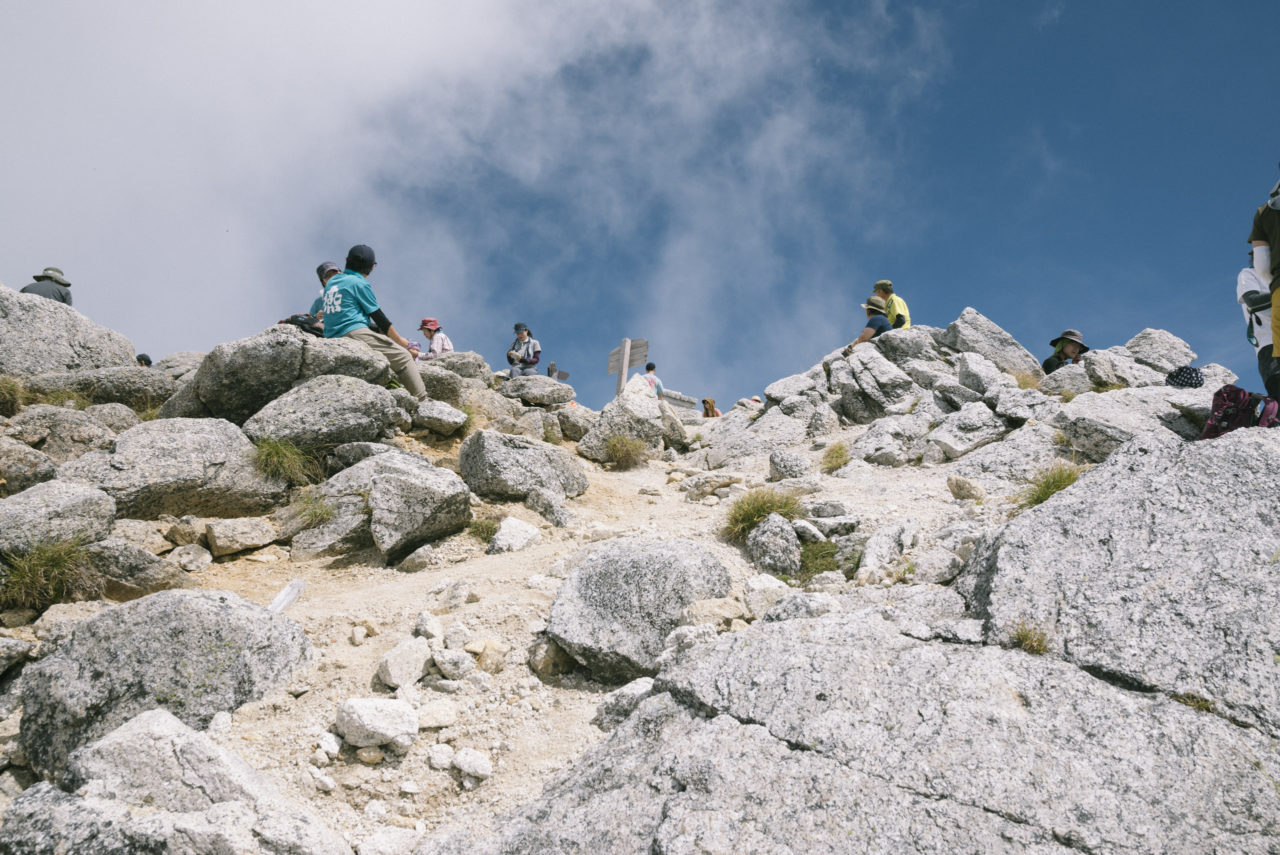 甲斐駒ヶ岳山頂で憩う登山者たち