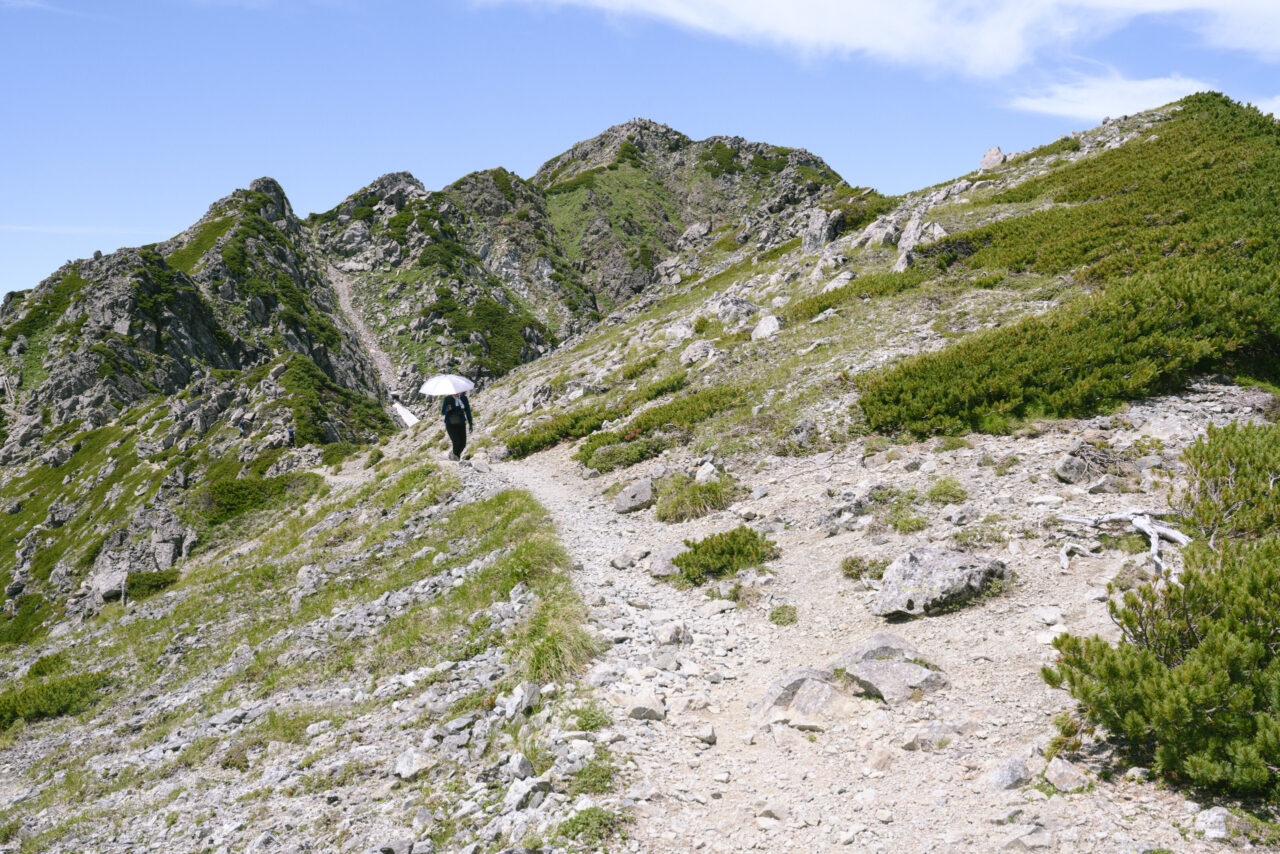 日傘をさす登山者
