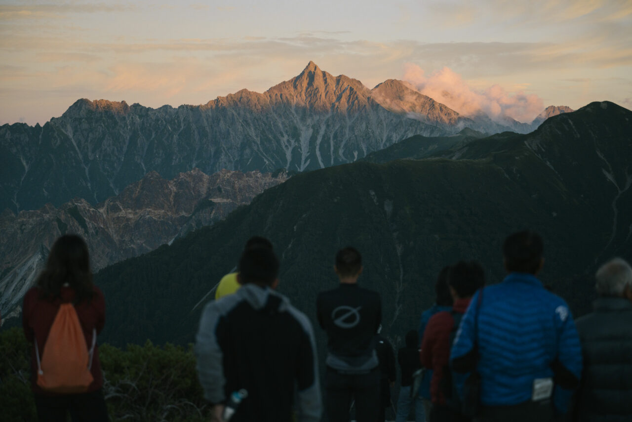 夕日に染まる槍ヶ岳を見る人々