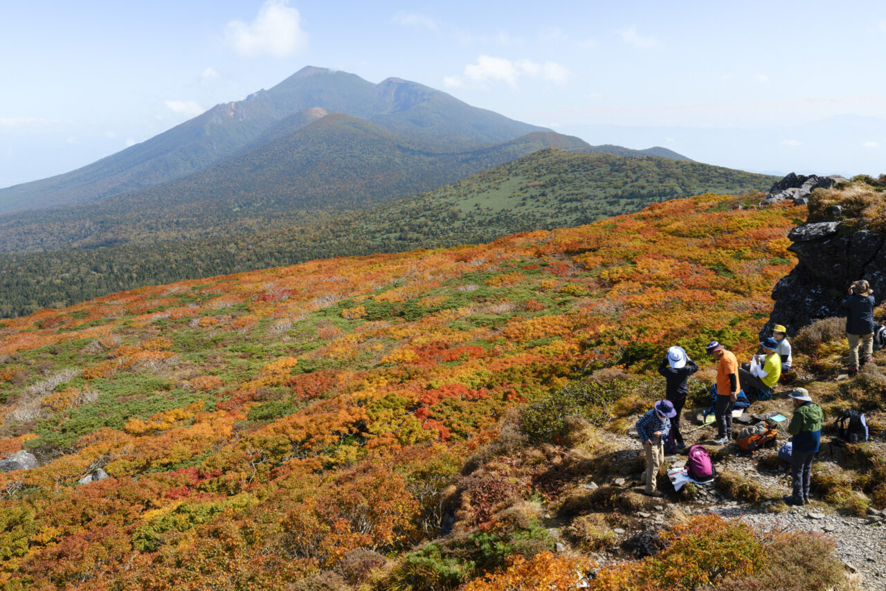 紅葉の三ツ石山山頂と岩手山を楽しむ登山者たち