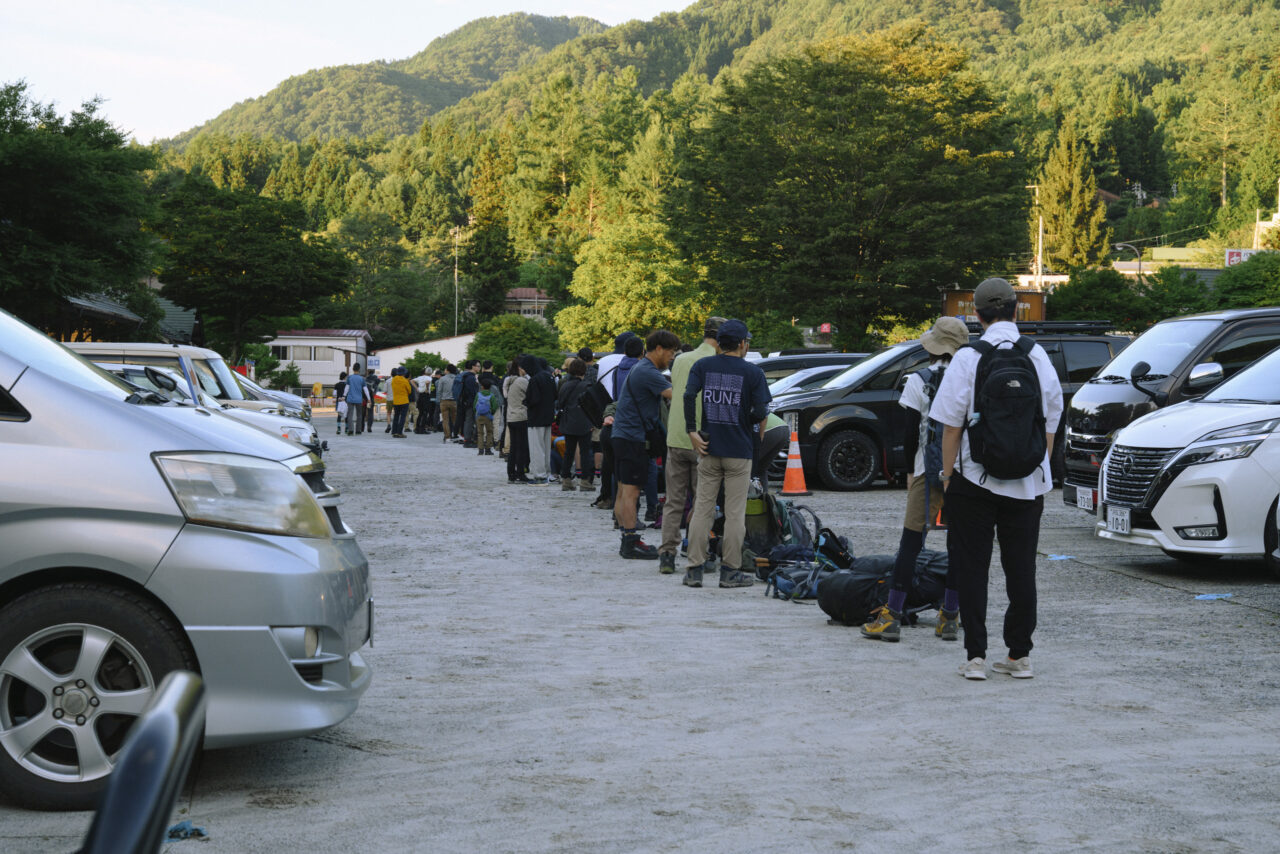早朝のバスに並ぶ登山者たち