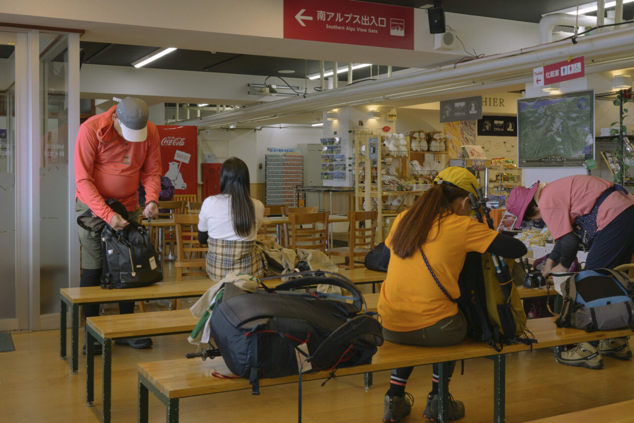 ロープウェイ山頂駅の売店で登山準備をする人々