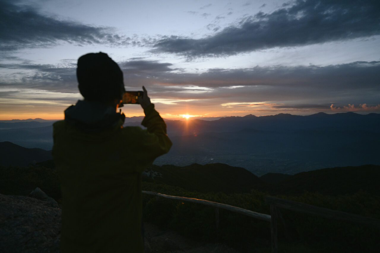 朝焼けを撮影する登山者